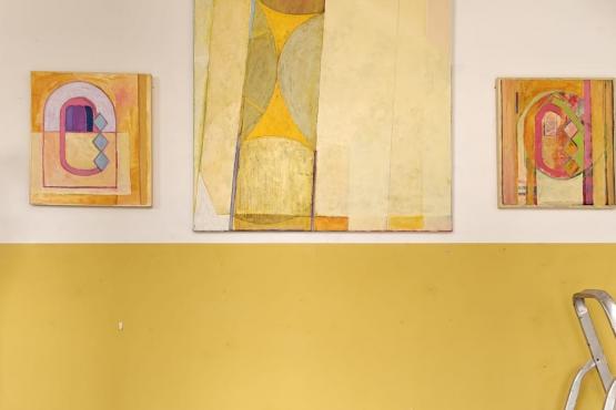 interior cafe with lower half yellow wall and 3 paintings