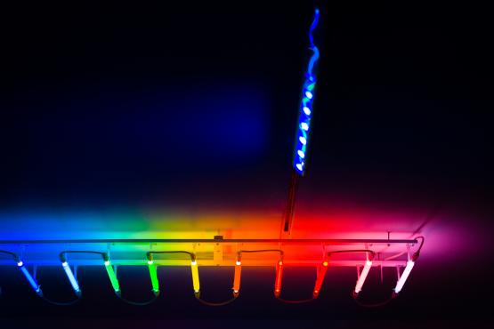 a strip of multicoloured strip lights on a black ceiling
