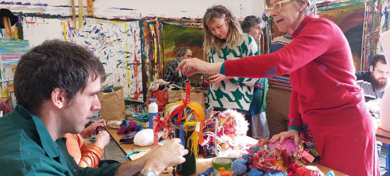 People playing with colourful textile materials in a studio space