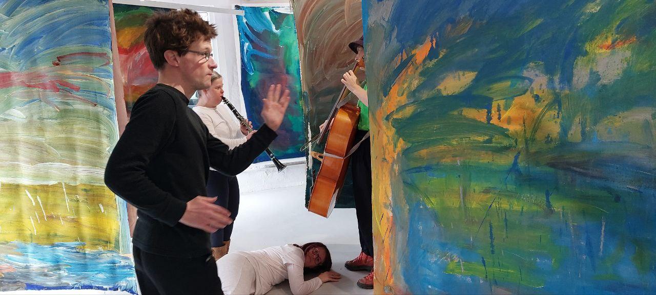 people dancing in front of abstract colourful paintings 